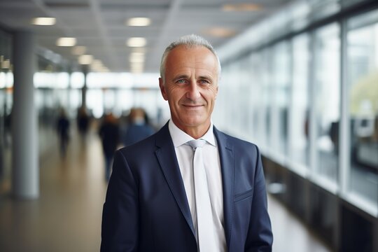 portrait of successful senior businessman consultant looking at camera and smiling inside modern office building
