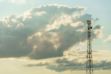 New GSM antennas on a high tower against a blue sky background. 5G signal transmissions are...