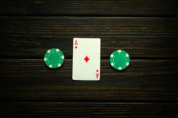 Ace of diamonds is good luck in the game of poker. Playing card and green chips on a dark vintage...
