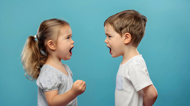 Side view of two toddler kids, preschool boy and girl arguing in blue studio. Angry children quarrel, shouting, upset brother and sister, siblings fighting, yelling, conflict - Powered by Adobe