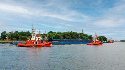 The Port of Gdansk, Poland, the Baltic Sea, assisted by the Bobr and Vega tugboats, enters the General Cargo Ship called Delta 1 © janmiko