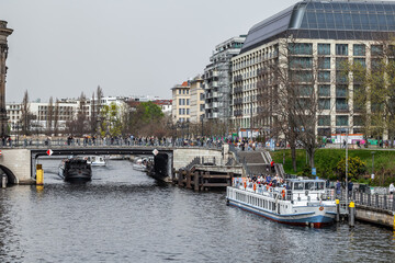 BERLIN, GERMANY - April 30, 2024: Berlin's waterways at Mühlendammschleuse, featuring a row of vintage motor boats peacefully docked along the serene canal, embodying the city's timeless charm.