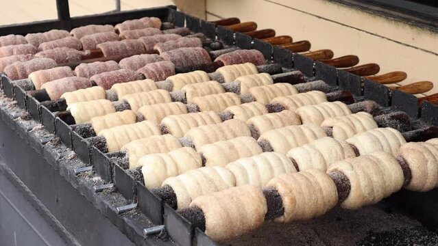 The process of baking trdelnik dough on a rotating spit