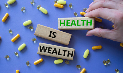 Health is Wealth symbol. Concept word Health is Wealth on wooden blocks. Doctor hand. Beautiful...