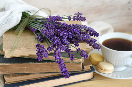 Lavender flowers on a stack of antique books with tea macarons - cozy reading concept - Powered by Adobe