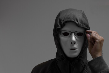 眼鏡のずれを直す白い仮面をつけた男性