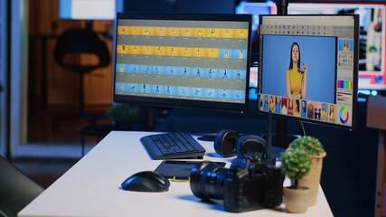 Creative agency studio desk with photo processing software interface on computer screens, graphic...