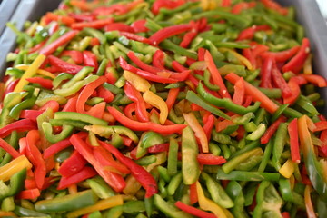 pimientos de tres colores, rojo, verde y amarillo en rajas
