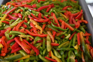 pimientos de tres colores, rojo, verde y amarillo en rajas