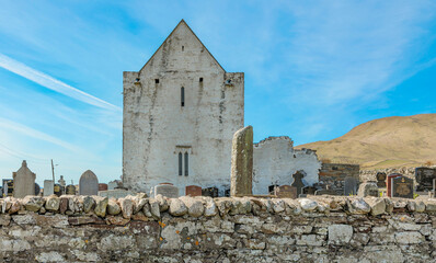 Ancient derelict church building against a blue sky
