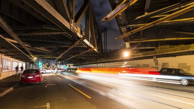 Timelapse of a gritty bridge underpass with cars with their headlights on whizzing by in Swan Street, Richmond, Melbourne, Victoria, Australia 