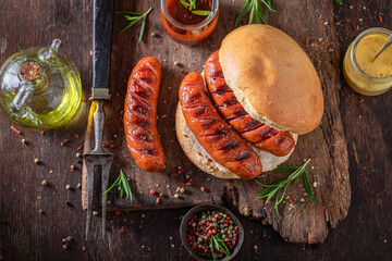 Spicy grilled sausage with bun and mustard and ketchup.