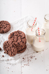 Tasty and homemade brown cookies served with milk in bottle.