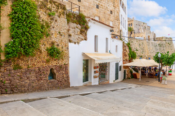 Picturesque sidewalk cafes and whitewashed shops along the wide pedestrian stairway from the fishing harbor to the walled old town in Ciutadella de Menorca, on the Balearic island of Menorca, Spain.