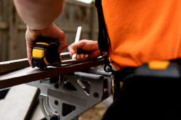  Measuring and marking a wooden board for precise cutting, ensuring accuracy in construction projects