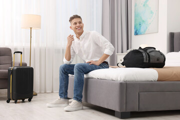 Smiling guest relaxing on bed in stylish hotel room