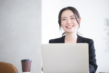 オフィスでパソコンを使う考える悩む(思いつく、思い出す）などのポーズの女性のクローズアップ　コピースペースあり