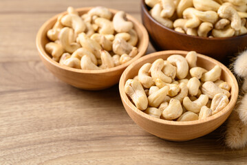 Raw cashew nuts in bowl on wooden background, Food ingredient
