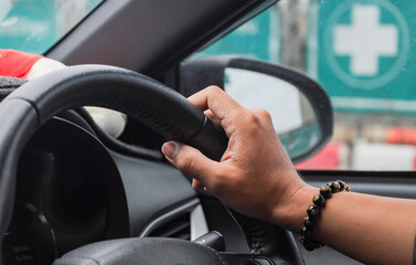 Photo of a man driving a car Take close-up shots of your arms and hands holding the steering wheel.