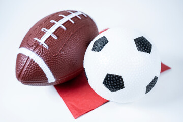 Football And Soccer Ball On A Red And White Background Up Close