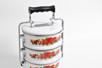 Vintage Tiffin or metal food container with floral motif isolated on white background
