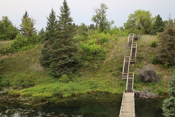 Fototapeta premium stairways lead the way from a bridge across a lake up a steep hillside 