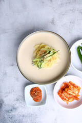 Korean-style cold bean noodles and side dishes against a bright background 밝은 배경에 한국식 콩국수와 반찬들