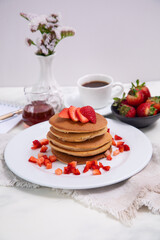 Stack of pancakes hotcakes with honey and strawberries breakfast food american style