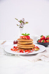 Stack of pancakes hotcakes with honey and strawberries breakfast food american style