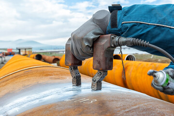Magnetic particle inspection (MPI) of pipe weld. It is a nondestructive testing process. To identify a leak, ferrous particles, either dry or in a wet suspension, are applied to a part. 
