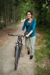 Obraz premium asian women holding a bike on the road at the forest