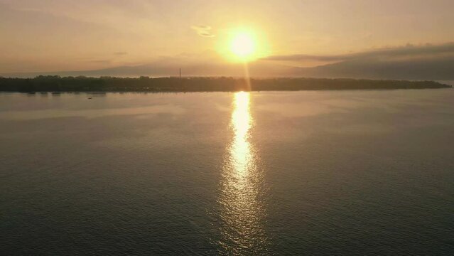 Sunrise sea surf washing beach drone view. Golden dawn sky over dark serene ocean water surface.
