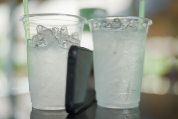 glass of water with ice and mobile phone