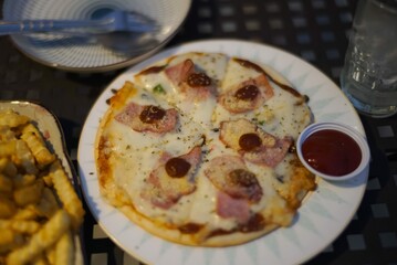 pizza with ham cheese on white plate