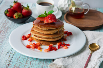 Stack of pancakes hotcakes with honey and strawberries breakfast food american style