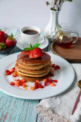 Stack of pancakes hotcakes with honey and strawberries breakfast food american style
