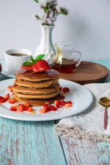 Stack of pancakes hotcakes with honey and strawberries breakfast food american style