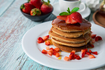 Stack of pancakes hotcakes with honey and strawberries breakfast food american style