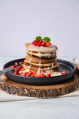 Stack of pancakes hotcakes with honey and strawberries breakfast food american style