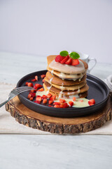 Stack of pancakes hotcakes with honey and strawberries breakfast food american style