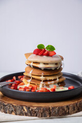 Stack of pancakes hotcakes with honey and strawberries breakfast food american style