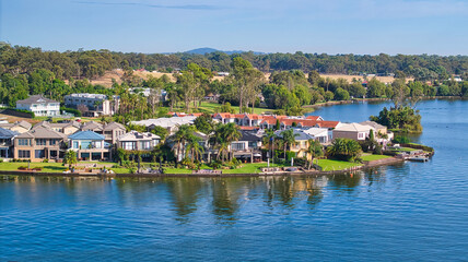 Fototapeta premium Large houses on the shore of Lake Mulwala with farmland and hills beyond