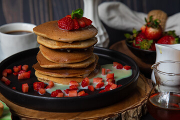 Stack of pancakes hotcakes with honey and strawberries breakfast food american style
