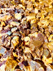 Close-up of raw beef pieces seasoned with vibrant turmeric powder, ready for cooking. The rich yellow spice contrasts beautifully with the fresh meat, highlighting a traditional culinary preparation p