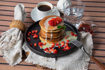 Stack of pancakes hotcakes with honey and strawberries breakfast food american style