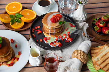 Stack of pancakes hotcakes with honey and strawberries breakfast food american style