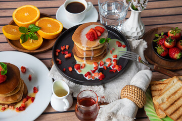 Stack of pancakes hotcakes with honey and strawberries breakfast food american style