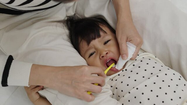 mother brushing her little daughters teeth. baby with tooth brush