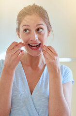 Home, teeth and woman with floss in bathroom for dental care, gum health and wellness. Happy girl,...
