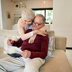 Obraz premium Senior couple, paperwork and hug in home with love, marriage and romance for husband and woman in lounge. Sofa, calculator and maths for bills with document, retirement fund or trust for happy people
